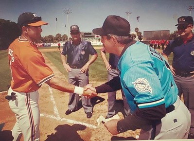 Manny Crespo Jr (left) shakes hands with his father, Manny Crespo Sr (right), prior to an exhibition game between the Miami Hurricanes and Florida Marlins in 2000.