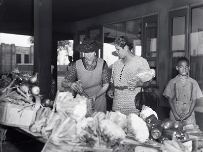 Des clientes achètent des légumes au marché Atwater à Montréal, 1945. Archives nationales à Montréal, fonds Conrad Poirier (P48, S1, P11922). Photo : Conrad Poirier. (Groupe CNW/Bibliothèque et Archives nationales du Québec)