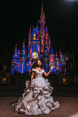 En honor al 50.° aniversario de Walt Disney World, la Disney Fairy Weddings Collection revela un vestido de novia de edición limitada, que tiene 15.000 cuentas brillantes, 3.000 cristales resplandecientes, 167 yardas de tela en total y 129 yardas de ribetes de crin de caballo. El vestido brilla frente al Faro de Magia en el Parque Magic Kingdom en Walt Disney World Resort en Lake Buena Vista, Florida (Disney). (PRNewsfoto/Disney's Fairy Tale Weddings & Honeymoons)