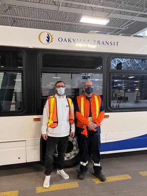 Two workers stand in front of Oakville Transit bus. (CNW Group/Unifor)