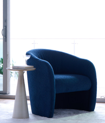 Mitchell Gold + Bob Williams Peyton chair, featuring easy-care Performance Textured Chenille in the Denim color, from the brand's exclusive new collection of luxurious recycled fabrics in collaboration with SEAQUAL INITIATIVE, a collaborative community helping to fight marine plastic pollution.