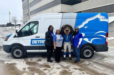 Comerica Southeast Michigan volunteer coordinators (L-R) Shayla Tartt, Antoinette Frost and Shaelese King meet up with Lions team mascot, Roary, as the team picked up literacy kits for Detroit elementary school students.