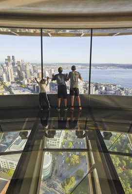 Guests standing on The Loupe, the world’s first revolving glass floor, looking out at downtown Seattle and Mt. Rainier. Courtesy Hufton & Crow.