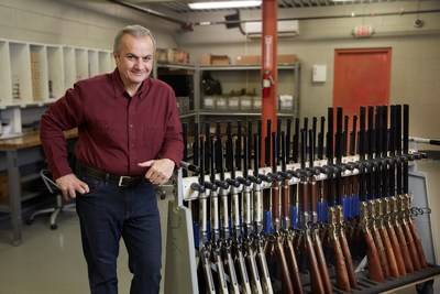 Henry Repeating Arms Founder and CEO Anthony Imperato with a rack of finished lever action rifles in the company's Bayonne, New Jersey facility.