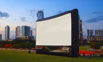 Massive outdoor movie screen by Ultimate Outdoor Movies® against a beautiful downtown skyline in Austin, TX