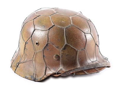 Authentic WWII German Luftwaffe M35 tri-color spray 'chicken wire' camouflage helmet known to collectors as a 'Normandy' style. Marked 'ET68' for the maker Eisenhuttenwerk/Herz. Luftwaffe eagle and national colors decals visible beneath camo paint. Vetted by Willi Zahn. Estimate $6,000-$8,000