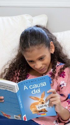 Young girl reading Scholastic book (PRNewsfoto/New Worlds Reading Initiative)
