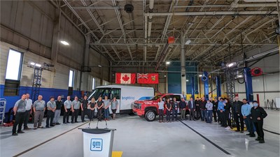 Unifor members stand together at the GM Oshawa test track in front of a Chevy Silverado assembled at the Oshawa plant and a BrightDrop commercial electric vehicle being built by workers at the CAMI plant in Ingersoll. (CNW Group/Unifor)
