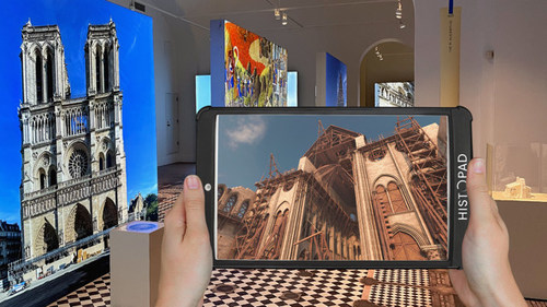 Using a Histopad™, a visitor views an augmented reality simulation of the construction of Notre-Dame de Paris in the exhibition. Credit: Histovery