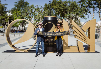 Pepsi’s Claudia Calderon and LAFC’s Larry Freedman pose with team scarves for Scarves Up For Good program.