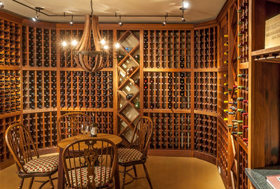 A climate-controlled wine room on the lowermost level of the main residence offers storage for 3,000 bottles and includes a cozy tasting area. Nearby is a kitchenette (not pictured). Visit DurangoLuxuryAuction.com for more details.