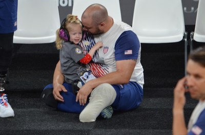 US Seated Volleyball player celebrates with his daughter at the Invictus Games The Hague. Fisher House Foundation sponsors the friends and family of US competitors so they can be there to celebrate their recovery from injuries or illnesses.