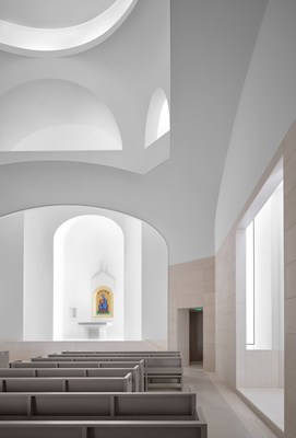 Concave light coves sculpted into the exterior reflect the powerful Texas sunlight indirectly into the Saint Sarkis church's interior space, resulting in an ethereal quality of illumination.