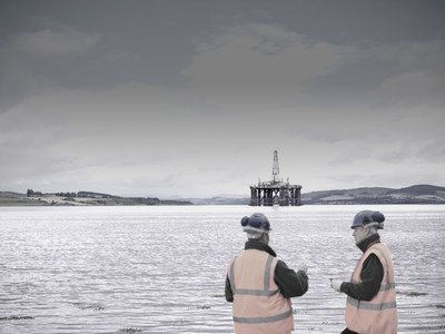Two Men with Offshore Drill Rig in Distance
