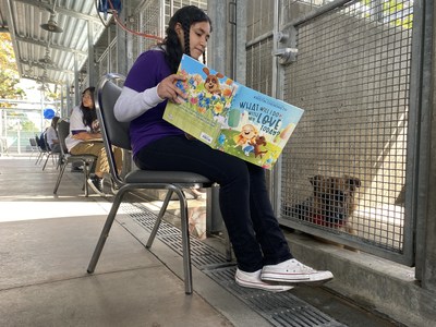 Child reading to a shelter dog during Los Angeles Animal Services "Read and Share Your Love" event.