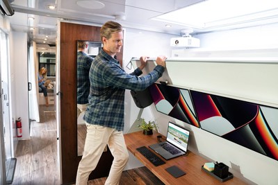 The entire Creative Studio is mounted above an 80" walnut one or two-person desk that can be effortlessly lowered without disturbing the active workspace, revealing a queen-sized Memory-Foam bed - photo credit Living Vehicle