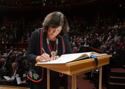 Patty Loew, Bad River, signs her name into the American Academy's Book of Members at the 2019 Induction Ceremony.