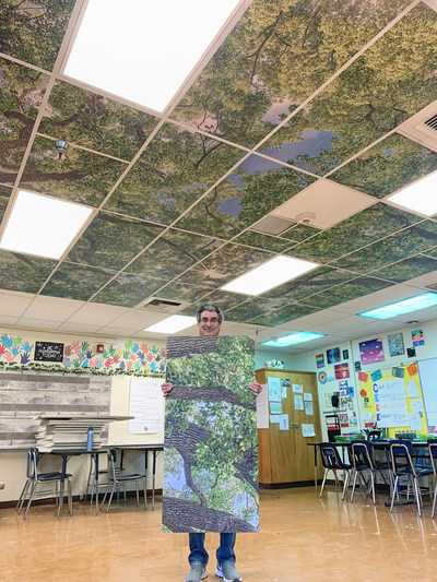Ernesto Rodriguez, Executive Director of Nature In The Classroom displays a ceiling tile. Ceilings murals come in two sizes: 12ft X 12ft or 16ft X 16ft.