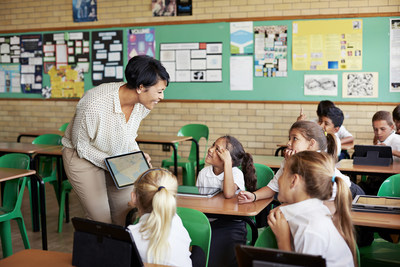 School children in uniforms in class with tablets School children in uniforms in class with tablets