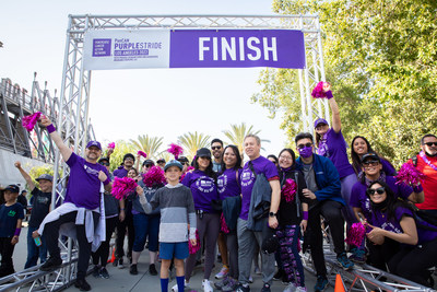 Participants pose in front of the finish line at PurpleStride Los Angeles on Saturday, April 30, 2022.