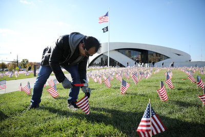Big Lots associate Ethan Prak places American flags at the National Veterans Memorial and Museum.