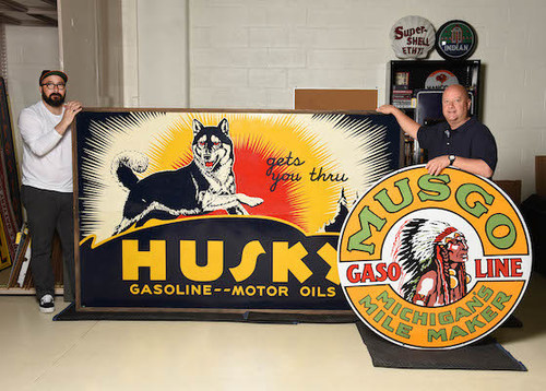 L to R: John Mihovetz, head of Morphy Auctions' Automobilia and Petroliana department and Dan Morphy, president of Morphy Auctions, with two of Bobby Knudsen Jr's favorite gasoline signs, advertising the brands Husky (auction low estimate $125,000) and Musgo (auction low estimate $275,000), respectively. Morphy Auctions image