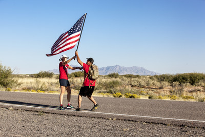 Team Red, White & Blue members pass an American Flag during Old Glory Relay.