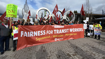Crowd in front of the Olympic rings in Whistler, B.C. holding a "Fairness for Transit Workers" banner (CNW Group/Unifor)