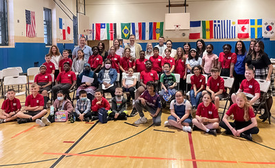 School leaders, teachers, and students from P.S. 60, along with St. Cadoc's and St. Peter's primary schools (Wales, U.K.) gather for a group photo inside P.S. 60's gymnasium.