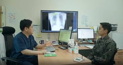 Medical professional consulting a patient with analysis result of Lunit INSIGHT CXR; staged photo