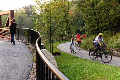 People ride bicycles and walk on the Herring Run Trail, a multiuse trail in Baltimore. Increased visitation to outdoor destinations emphasizes the need for everyone to #RecreateResponsibly. Photo by Side A Photography, courtesy of Rails-to-Trails Conservancy.