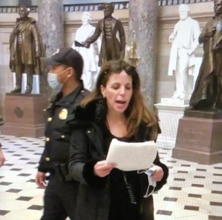 Dr. Gold delivering prepared remarks in U.S. Capitol on Jan. 6, as Police Officer watches on casually.