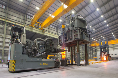 Shown here is a Glama 50,000 Lb. capacity forging manipulator, loading a hot forging into a 6,500 ton forging press. In the background is a 3,300 ton forging press with a hot forging loaded in it.