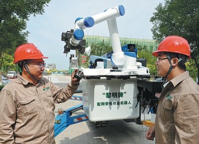 Staff members with State Grid Tianjin Electric Power Company explain how to use a robot with artificial intelligence to help with wiring.