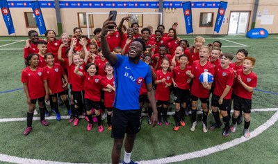 Alphonso Davies is pictured with local youth at his soccer club Born to Be in Edmonton, celebrating him signing on as BMO's new ambassador. (CNW Group/BMO Financial Group)