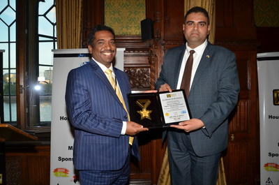 Dr J Sundeep Aanand receiving the Asian UK Achiever's Award 2022 from Rajesh Agrawal, Deputy Mayor, London at the House of Commons