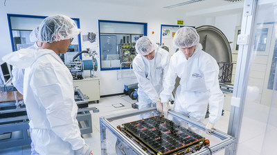 ICEYE specialists inspecting an ICEYE SAR satellite in a clean room.