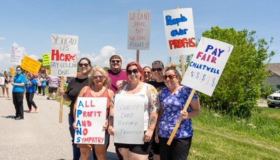 Worker's picketing holding signs outside a long term care home (CNW Group/Unifor)