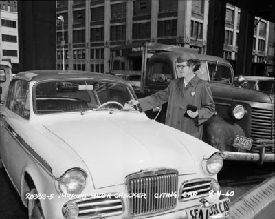 Checker giving a parking ticket, Seattle Washington, 1960. Photo - Seattle Municipal Archives, Seattle, WA