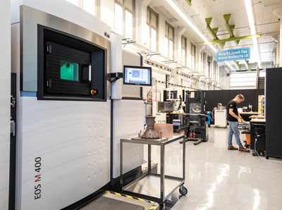 Rocket propulsion company Ursa Major’s Advanced Manufacturing Lab in Youngstown, Ohio, where its EOS laser powder bed fusion 3D printer (left) produces rocket engine components on demand. Technician Ty Barzak setting up for a new build (right).