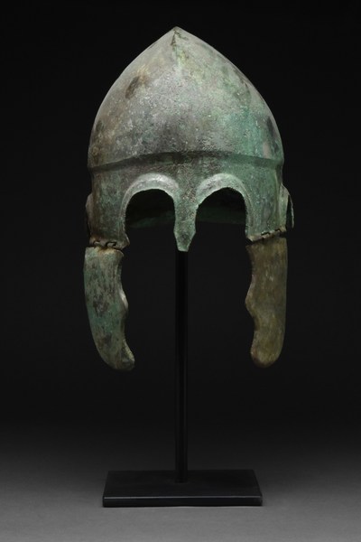 Ancient Greek bronze Chalcidian helmet, circa 400 B.C., forged in one piece with high-arched eyebrows below a peaked, raised band, and with a teardrop-shape nose guard. Similar to example in The Walters Art Museum collection. Provenance: private UK collection, acquired on German art market pre-2000. Accompanied by professional historical report from Ancient Report Specialists. Estimate £6,000-£9,000 ($7,215-$10,825)