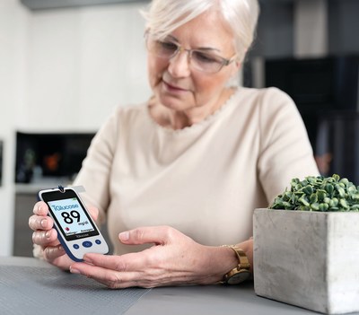 Senior woman with glucometer checking blood sugar level at home. Diabetes, health care concept