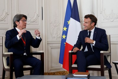 French President Emmanuel Macron (R) speaks with ProLogium CEO Vincent Yang (L) during a meeting as part of the 5th edition of the 