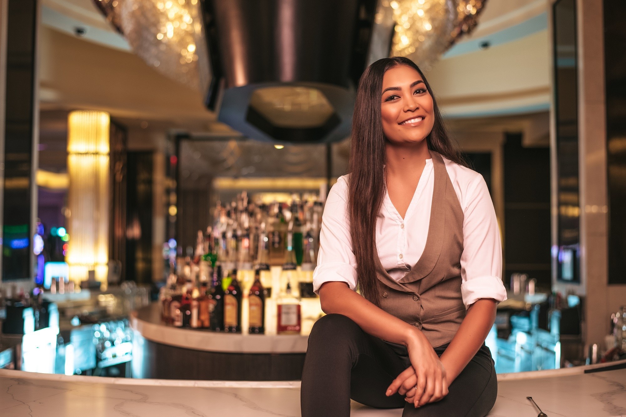 Barman feminino posando no topo de um bar