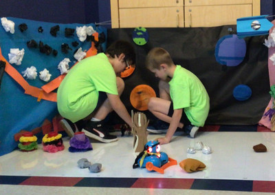 Children learn how to think creatively and solve problems through designing an original invention during a junior robotics challenge at the Primrose Schools Summer Adventure Club.