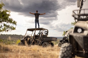 Person on top of American Landmaster UTV