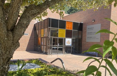 Photo of six high-performance photovoltaic windows, each roughly four-feet by four-feet, with three distinct colors, recently installed at the Western Washington University Art Gallery on campus in Bellingham, Washington. Photo credit: UbiQD, Inc.