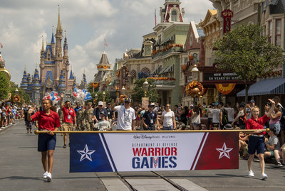 Department of Defense Warrior Games athletes serve as the honorary grand marshals in a celebratory welcome parade at Magic Kingdom Park at Walt Disney World Resort in Lake Buena Vista, Fla. The athletes, joined by U.S. Army General Paul E. Funk, and representing the Army, Navy, Air Force, Special Operations Command and Marine Corps, as well as Canada and Ukraine, took turns carrying the Warrior Games torch that will light the cauldron at Friday's opening ceremony at ESPN Wide World of Sports.