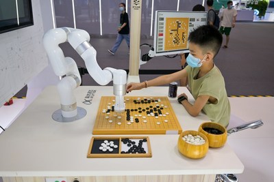 Um garoto joga Go com um robô no salão de exposições da SCE 2022, em 21 de agosto de 2022, em Chongqing, na China. (PRNewsfoto/iChongqing)