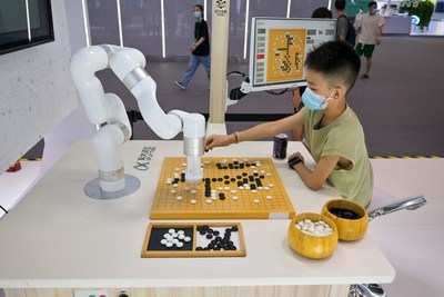A boy plays Go with a robot in the exhibition hall of SCE 2022, on 21st August 2022, Chongqing, China. (photo/ Ganxi Yi) (PRNewsfoto/iChongqing)
